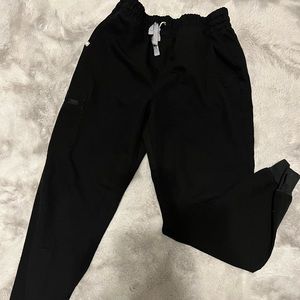 In use condition black Fig scrubs pit stain in a photo